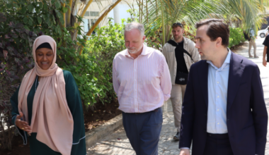 Bistånds- och utrikeshandelsminister Benjamin Dousa promenerar tillsammans med två andra vid Elman Peace Center i Somalia.