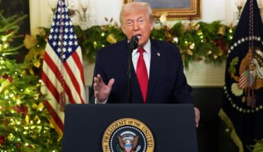 Donald Trump steht an einem Redepult und spricht in Richtung Kamera. Im Hintergrund ist eine US-Flagge zu sehen.