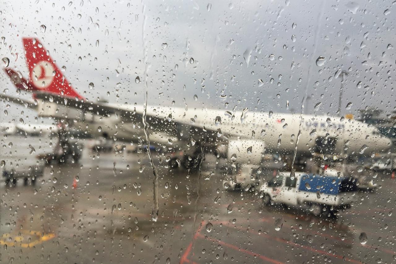 File photo shows a blurred view of a Turkish Airlines aircraft parked at the gate through an airport window covered with raindrops, accessed on Feb. 5, 2025 (Adobe Stock Photo)