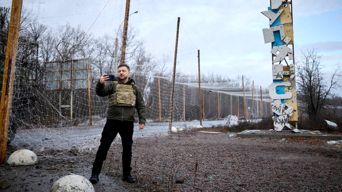 Ukraine’s president films himself near a town sign in an active conflict zone.