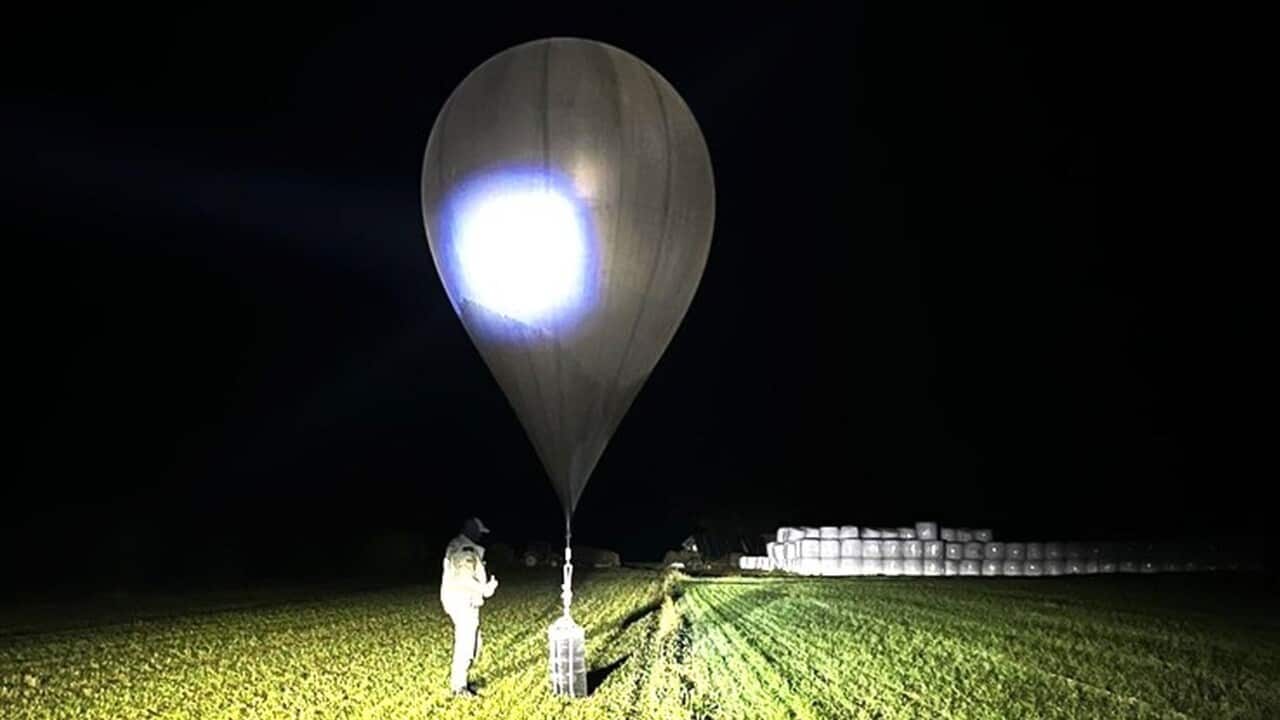 An officer inspects a balloon used to carry cigarettes from Belarus into Lithuania.