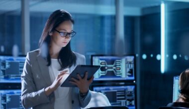 An IT professional checks a tablet computer in a data center.
