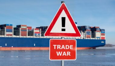 A picture of a container ship behind a sign that says "Trade War."