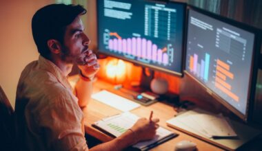 Man takes notes as he looks at computer screen showing investments.