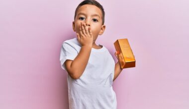 Toddler holds a gold bar.