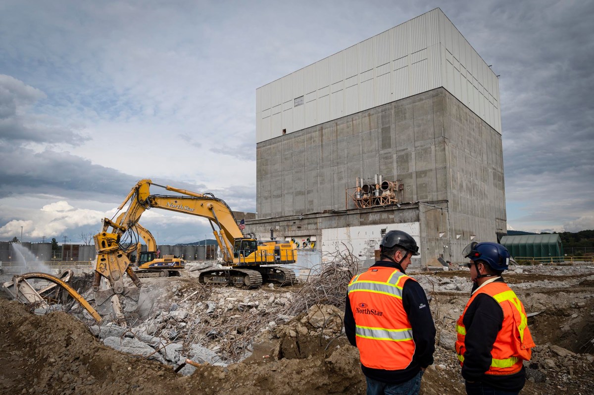 A group of construction workers standing in front of a large building.