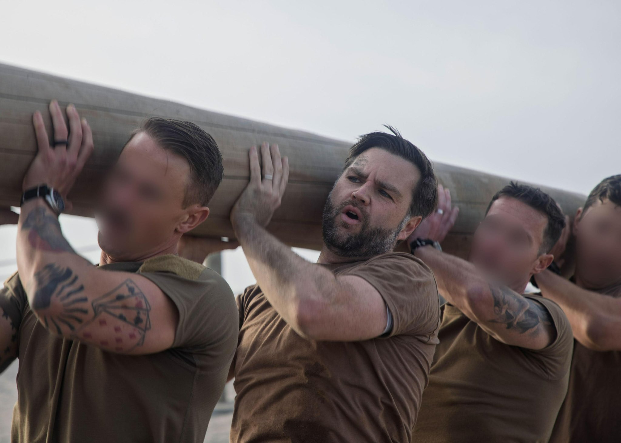 Vice President JD Vance trains with Navy Seals, carrying a large log with other men.