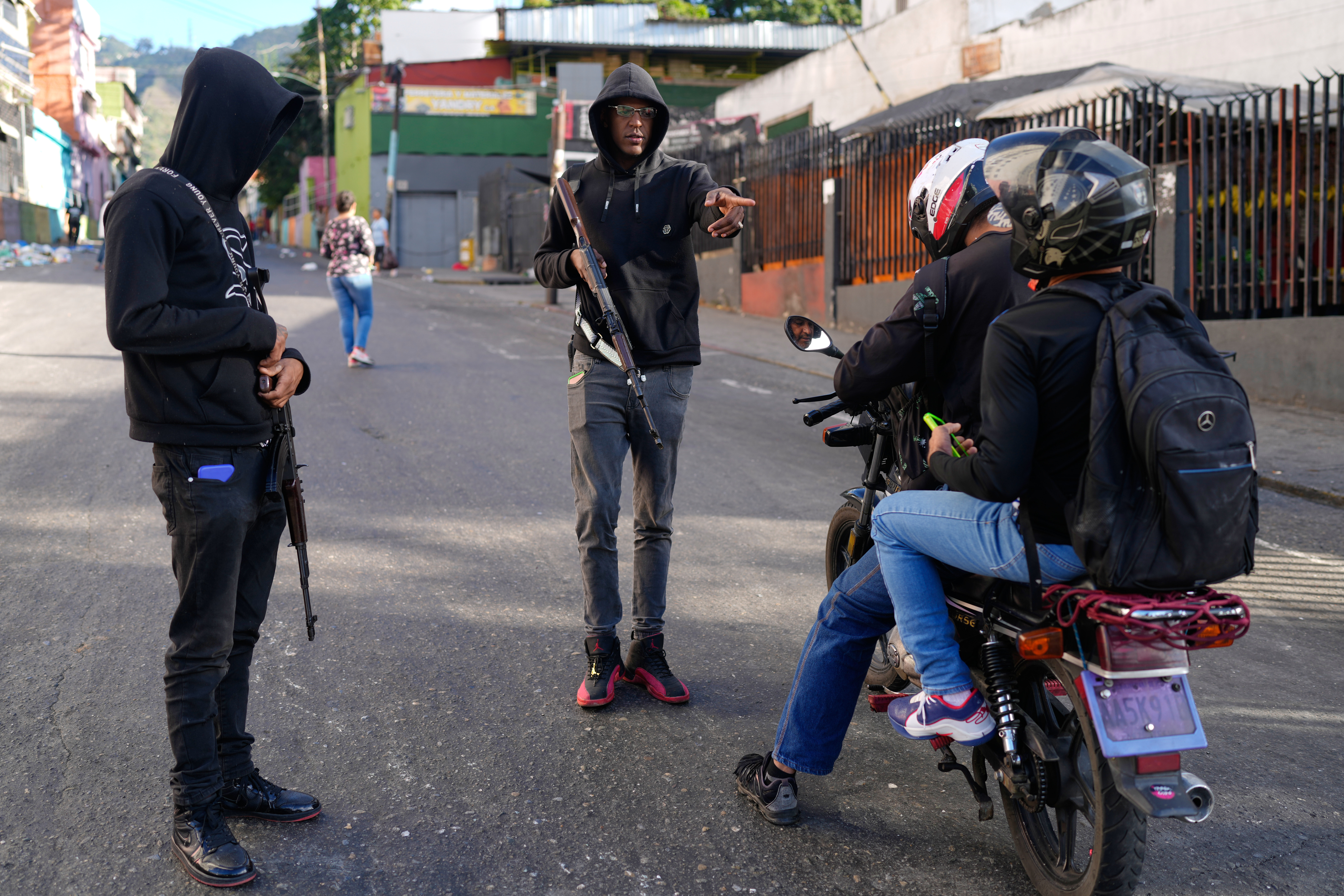 Armed pro-government civilians stop motorcyclists in Caracas on Sunday