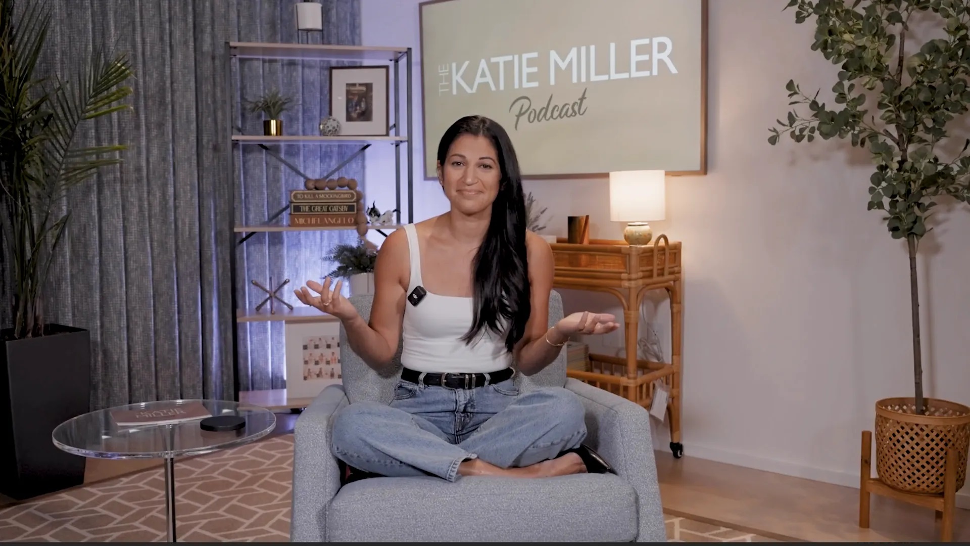 Screenshot from "The Katie Miller Podcast" showing Katie Miller sitting cross-legged in a chair.