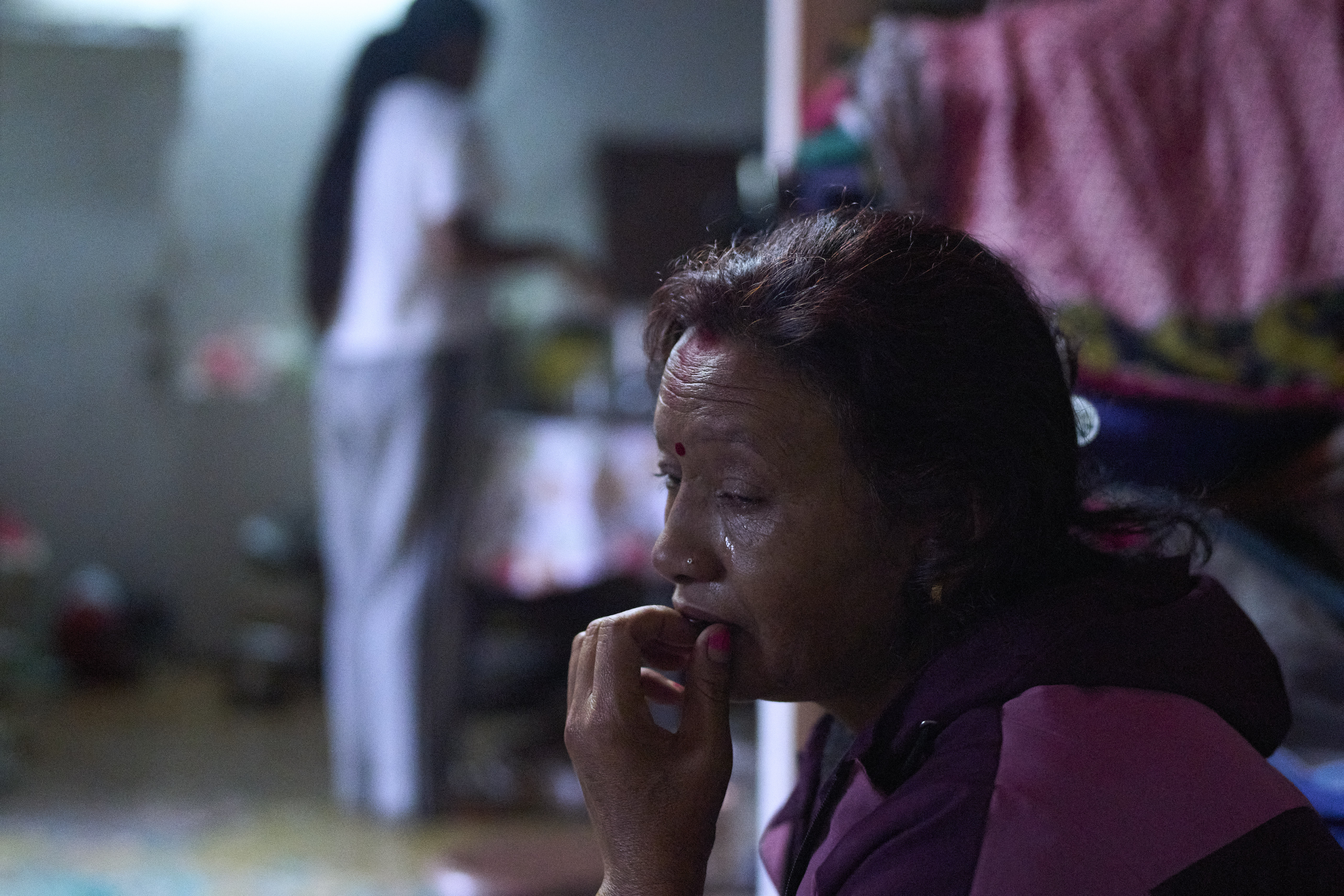 Jeena Lamichane crying while holding a piece of bread at her residence in Kathmandu, Nepal.