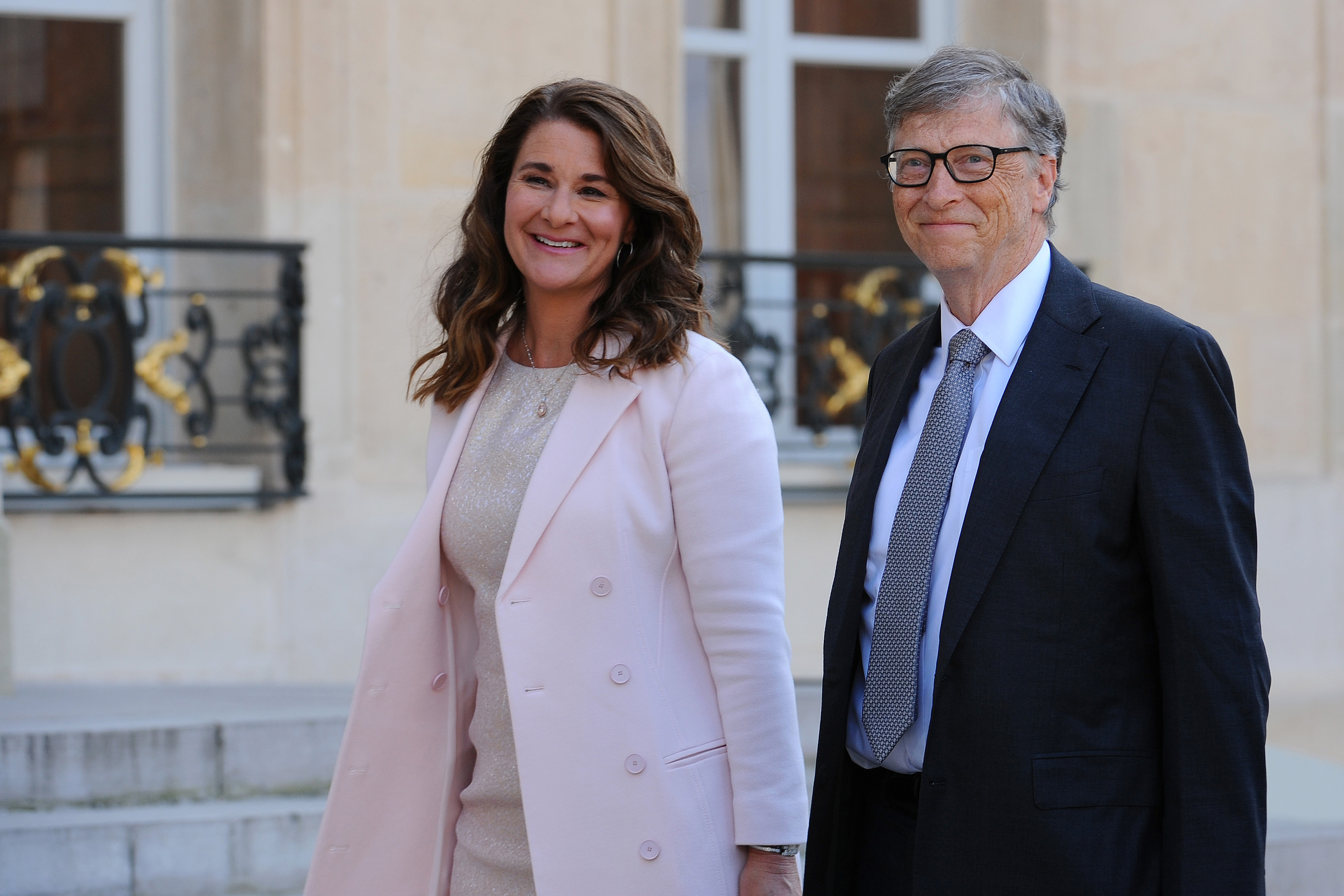 Bill and Melinda Gates smiling as they arrive at the Elysee Palace.