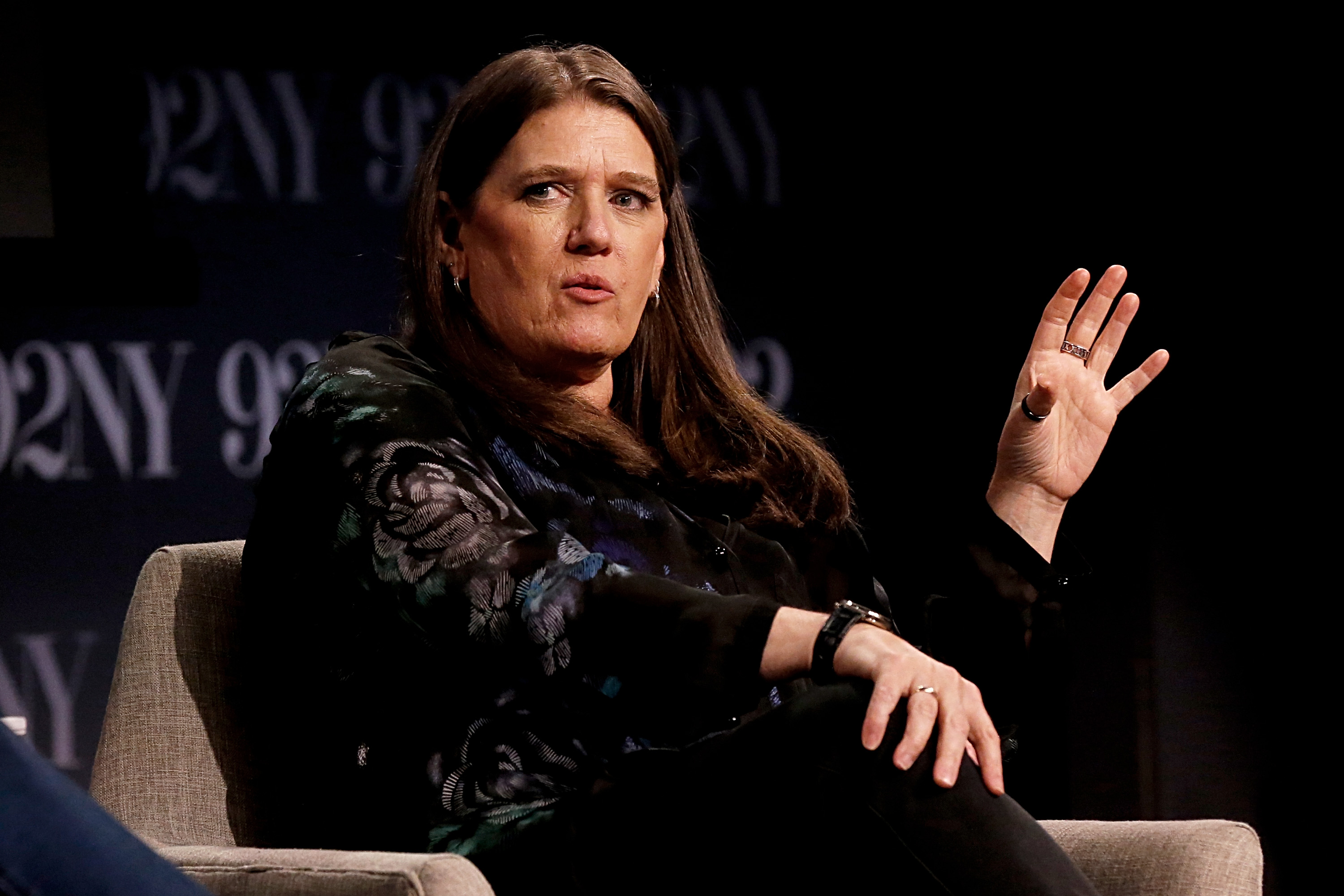 Mary Trump speaking at a book event with her hand raised.