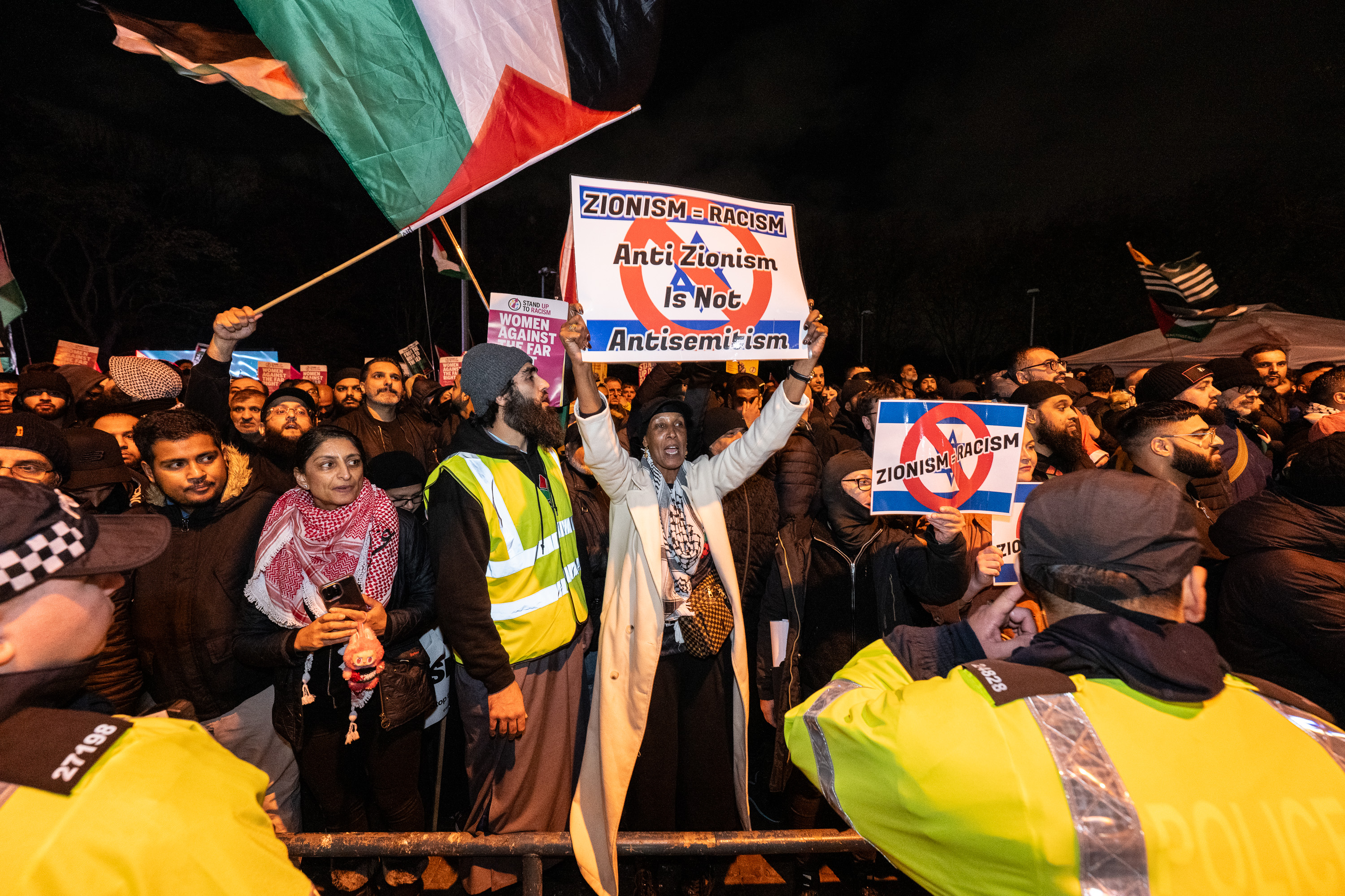 Pro-Palestine activists protesting at Villa Park, holding signs that read "Zionism = Racism, Anti Zionism Is Not Antisemitism".