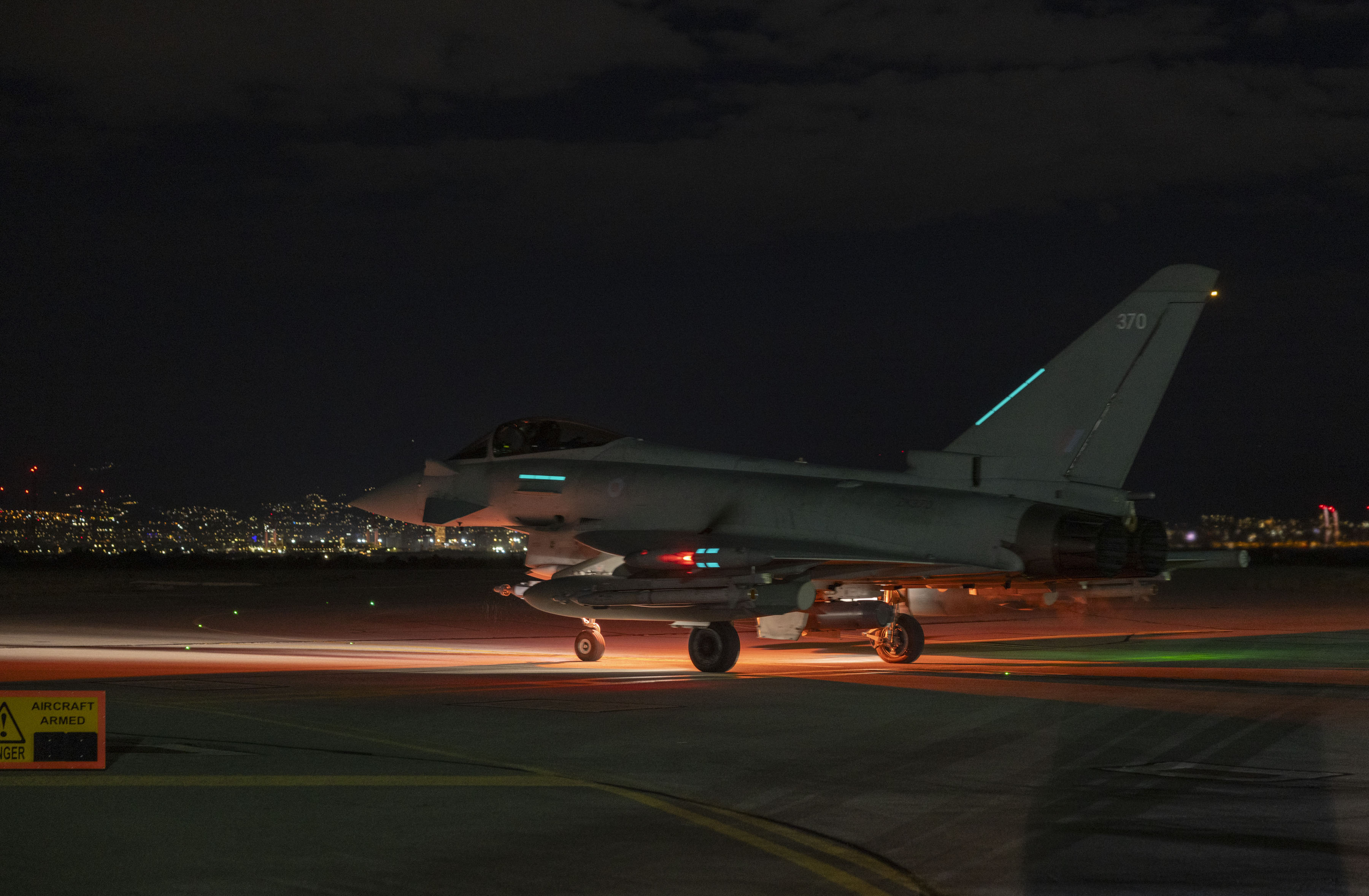 Royal Air Force Typhoon aircraft preparing for takeoff at night.