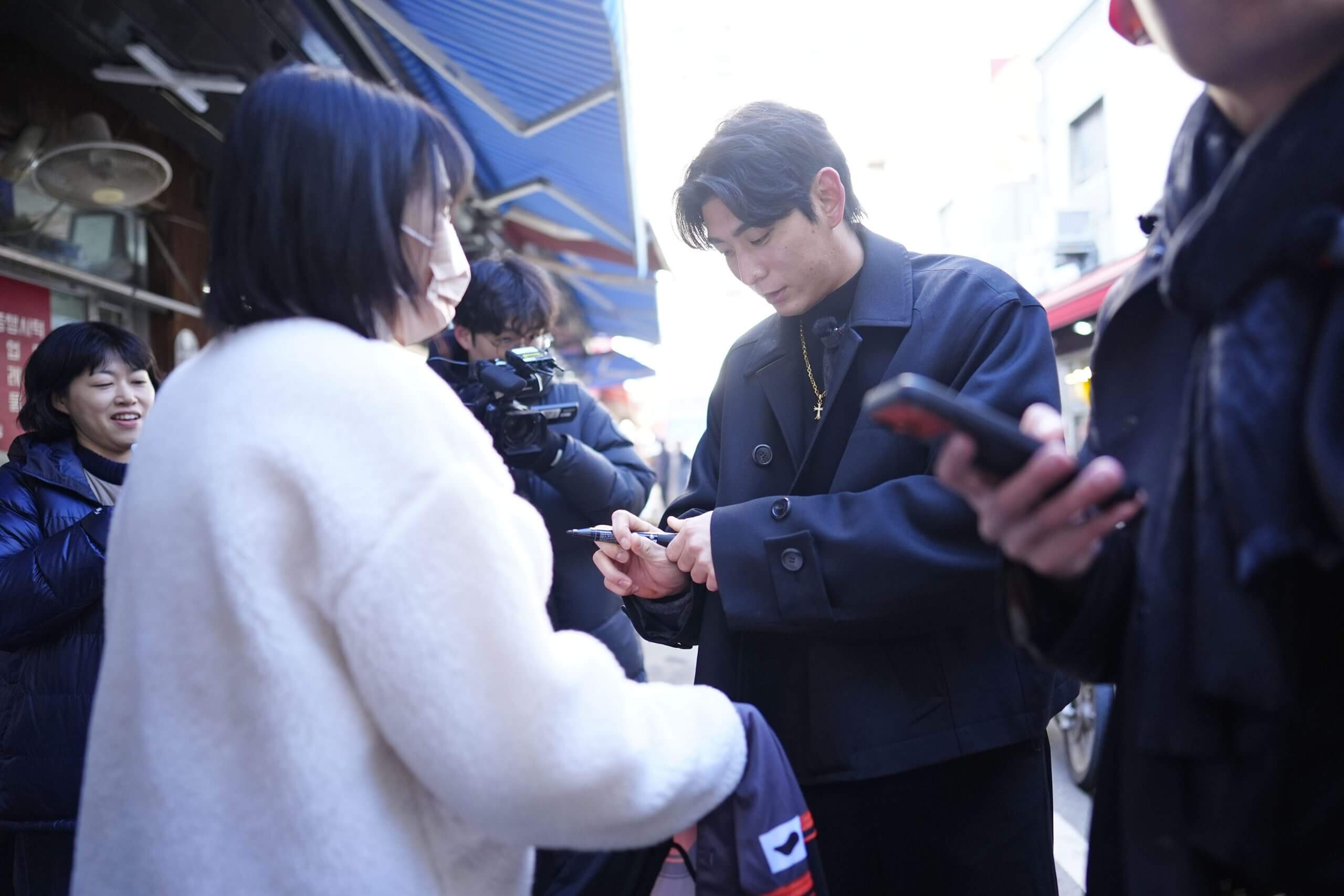 Jung Hoo Lee of the San Francisco Giants signs an autograph at the Namdaemun Market.
