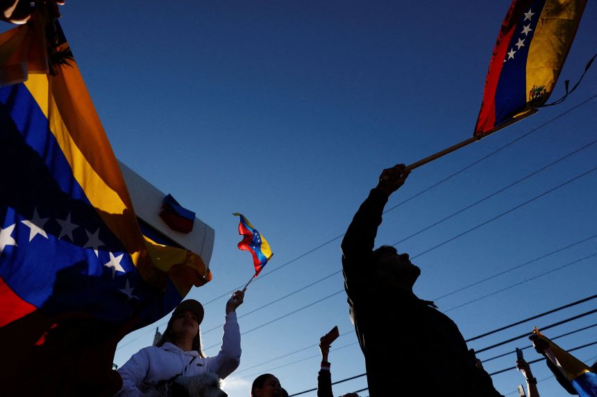 People in Doral, Florida, hold Venezuelan flags after the capture of Maduro on Saturday.