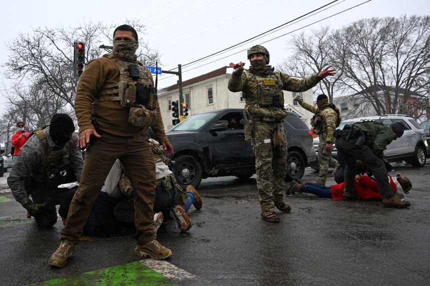 US Border Patrol agents detain bystanders during a confrontation in an intersection in Minneapolis, Minnesota, on January 21, 2026.