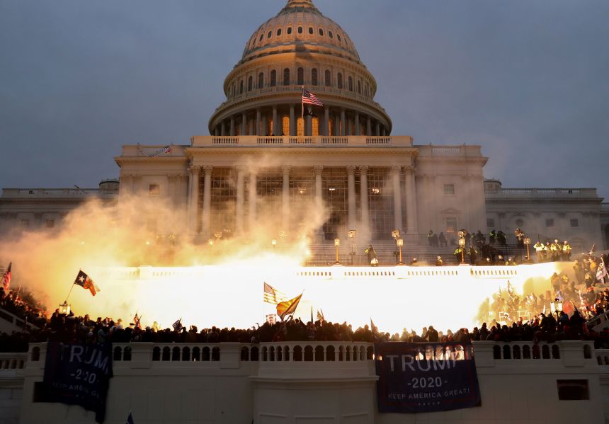 An explosion caused by a police munition is seen while supporters of President Donald Trump riot in front of the US Capitol on January 6, 2021.