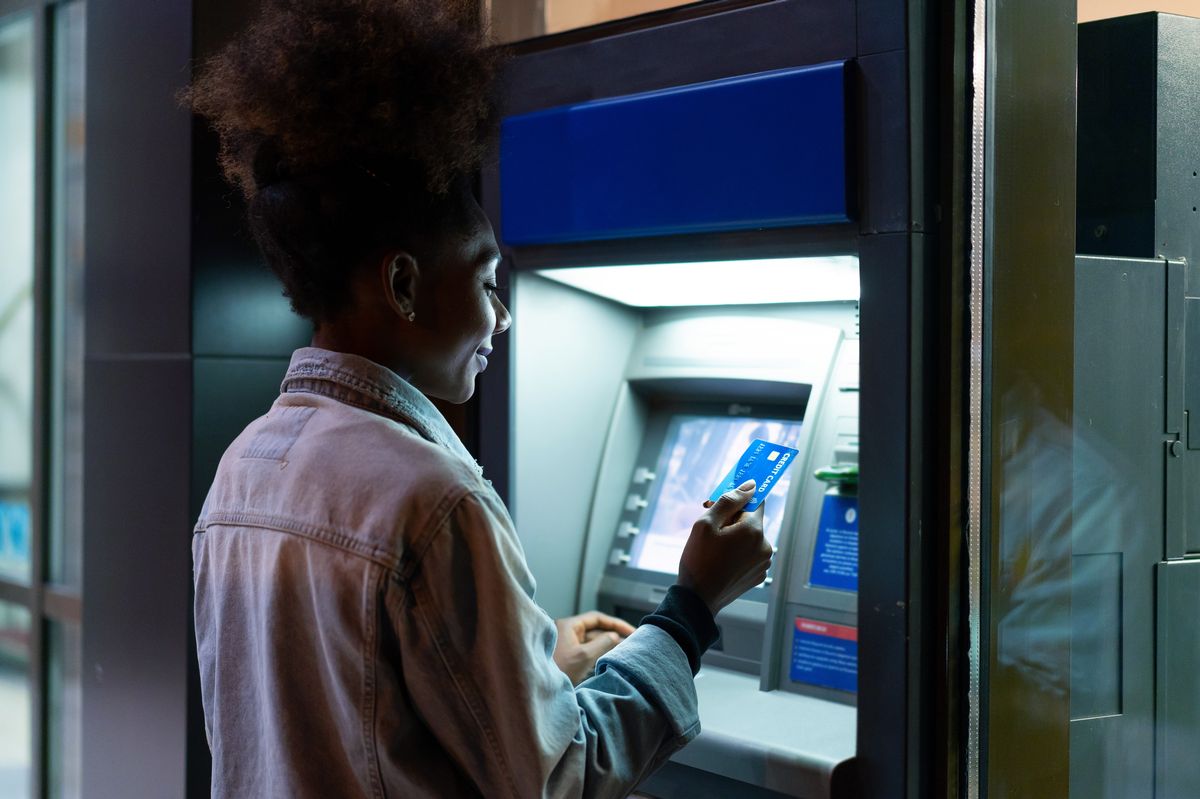 Afro American woman withdrawing money at the ATM