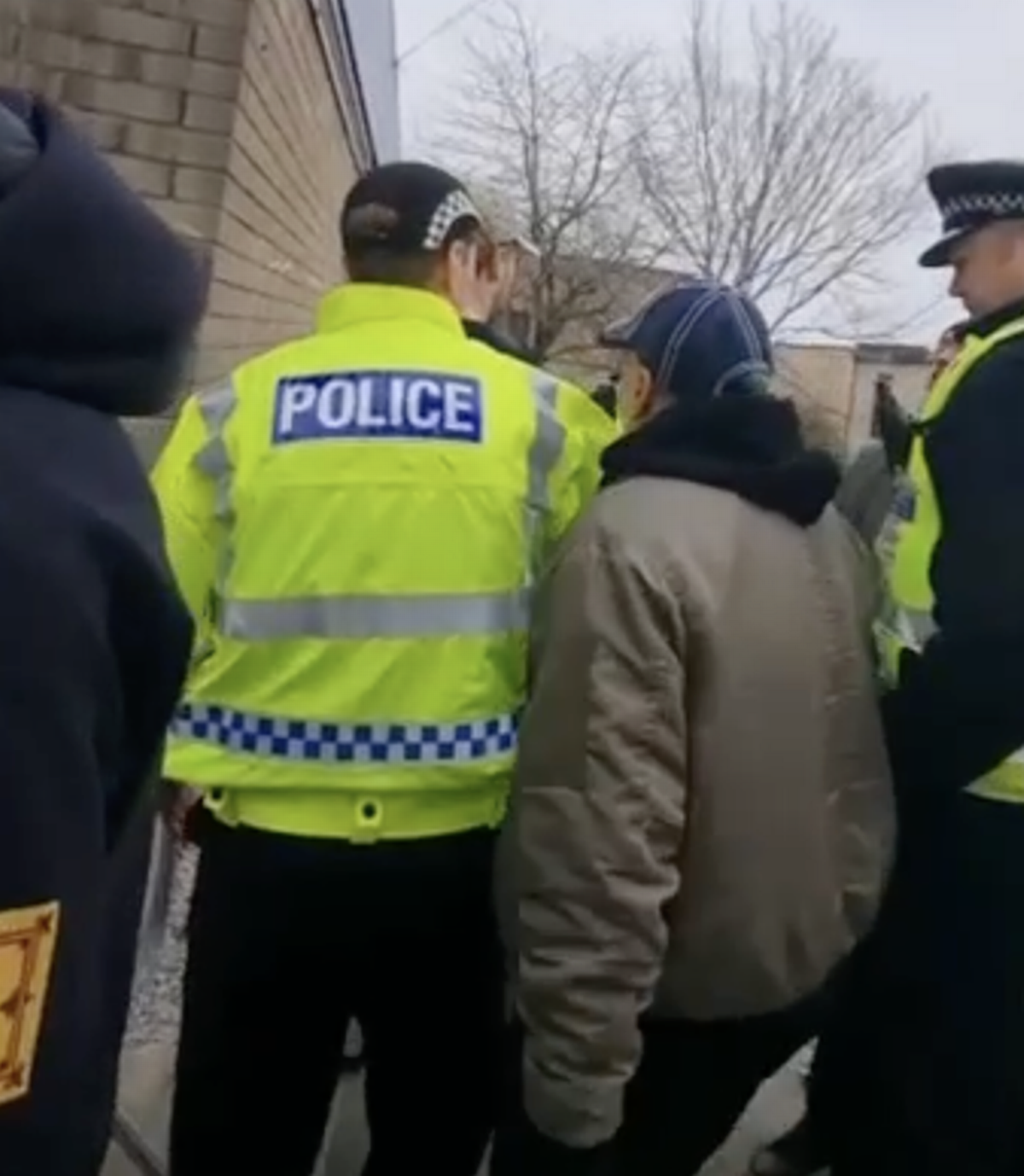 A protester shouts and attempts to pursue a resident who had come out to speak to the group