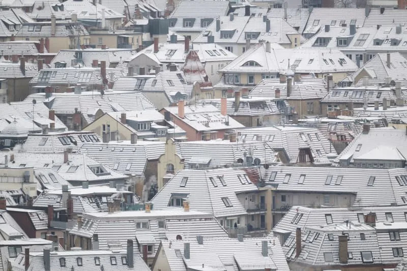 Snow-covered roofs can be seen in the city center. Germany's heating bills set to rise as colder weather drives up costs Marijan Murat/dpa