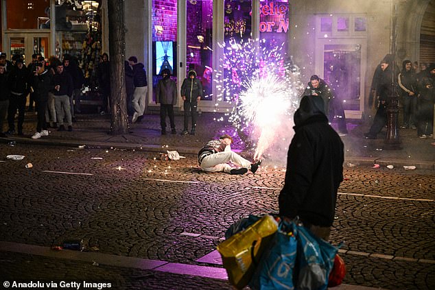 Police intervenes during New Year's Eve celebrations at Dam Square after disturbances broke out involving groups of youths setting off fireworks indiscriminately in Amsterdam