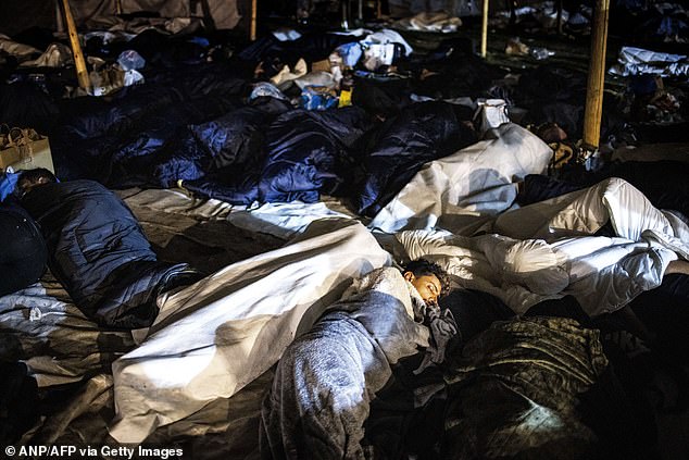 Asylum seekers sleep on the ground for a the third night in a row, outside the registration and application center in Ter Apel, on August 26, 2022