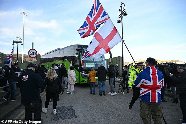 Protesters stop a coach as they gather outside a processing centre for migrants in Dover, Kent today