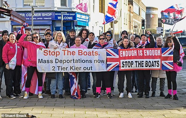 Women stand with banners which read: 'Stop The Boats' and 'Enough is Enough' in Kent