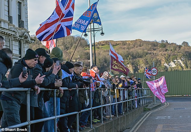 A group of demonstrators wave flags and banners as they protest against immigration in Dover today
