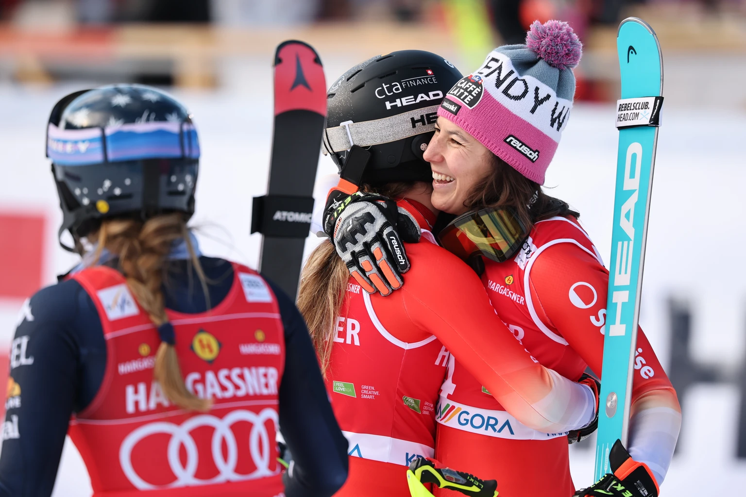 Third placed Switzerland's Wendy Holdener, right, congratulates winner Switzerland's Camille Rast as United States' Mikaela Shiffrin , left, looks on, at the finish line during an alpin ...