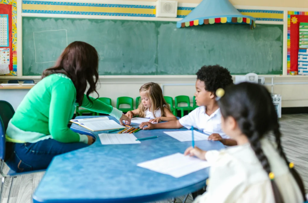 Symbolfoto auf 5min.at zeigt eine Lehrerin mit Schülern.