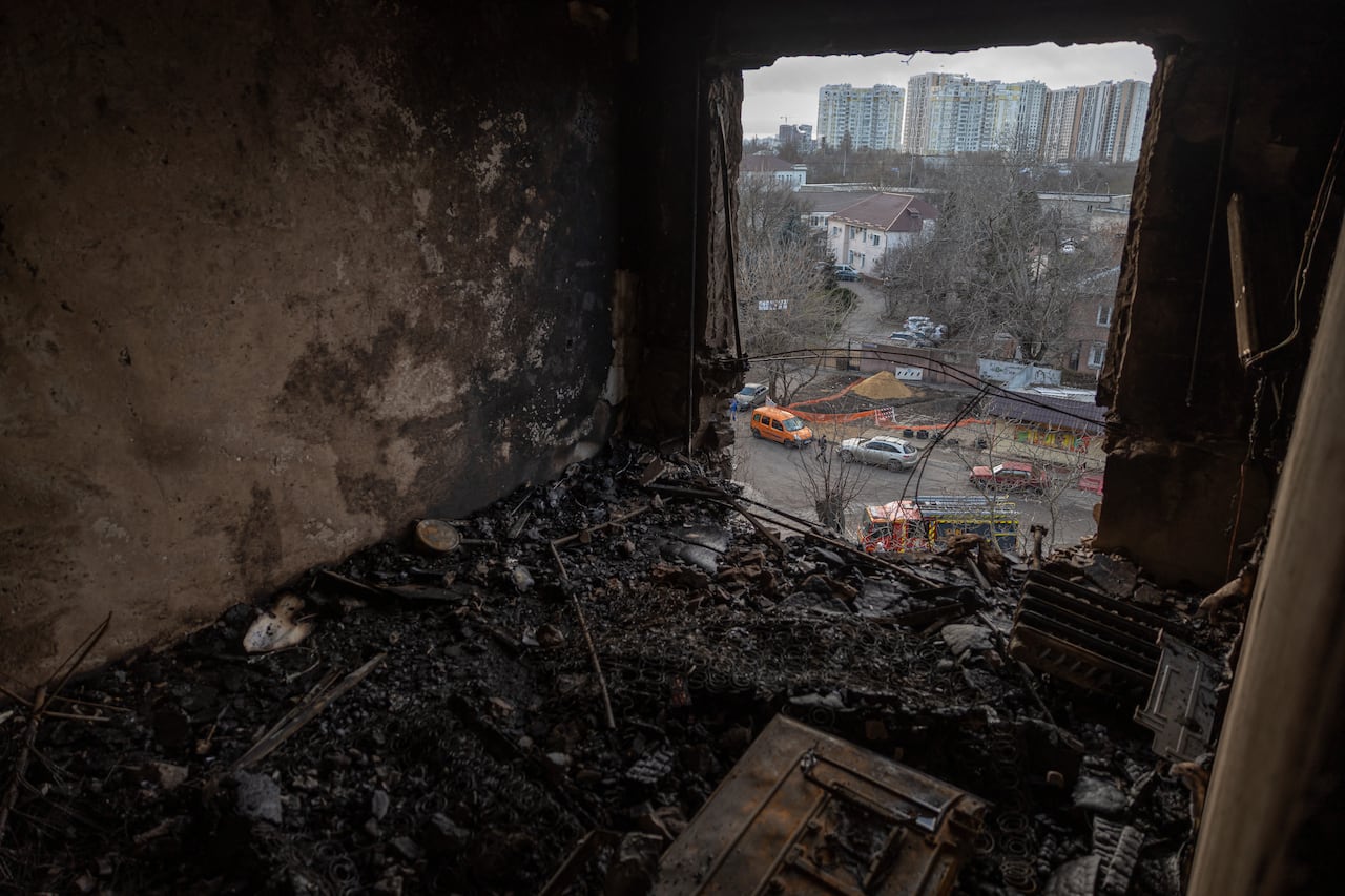 A heavily damaged apartment is pictured as the street in seen below through a large hole in the wall.