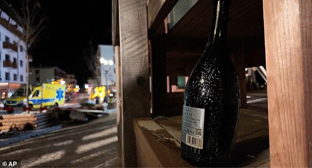 A bottle of sparkling wine lies where a fire broke out leaving people dead and injured, during New Year's celebration, in Crans-Montana, Swiss Alps, Switzerland, Thursday, Jan. 1, 2026. (Police Cantonale Valaisanne via AP)