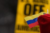 A protester wears a Venezuelan flag while rallying outside the White House, Saturday, Jan....