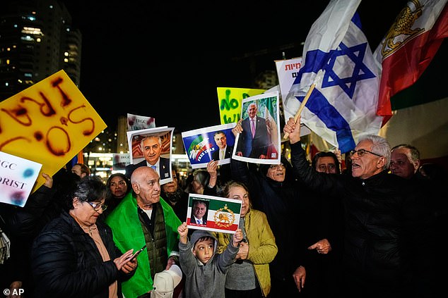 Demonstrators wave pre-revolution Iran flag, Israeli flag and posters of Iran's exiled crown prince Reza Pahlavi during a rally in support of Iran's anti-government protests, in Holon, Israel Wednesday, Jan. 14, 2026. (AP Photo/Ohad Zwigenberg)