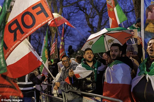 LONDON, ENGLAND - JANUARY 14: Protesters hold up flags outside the Iranian Embassy on January 14, 2026 in London, England. On Tuesday Foreign Secretary Yvette Cooper announced "full and further sanctions" against Iran in reaction to the regime's violent crackdown on demonstrations that have killed more than 2,500 protesters, according to HRANA, an Iranian human rights organization and news agency. The UK Foreign Office also summoned the Iranian ambassador, Seyed Ali Mousavi, over "horrific reports" of violence by Iranian authorities. (Photo by Dan Kitwood/Getty Images)