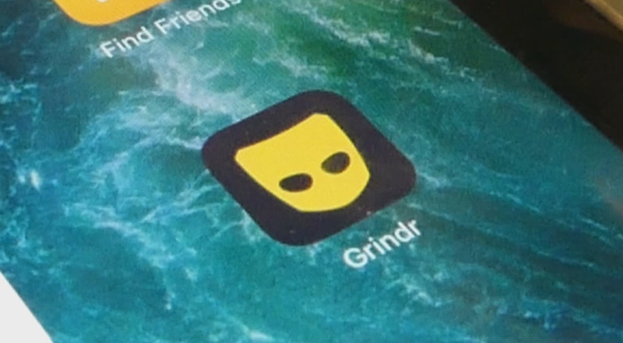 A phone app with a mask logo and the word 'Grindr'.