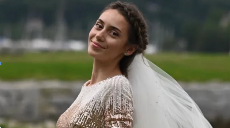 A woman in a veil looks at the camera