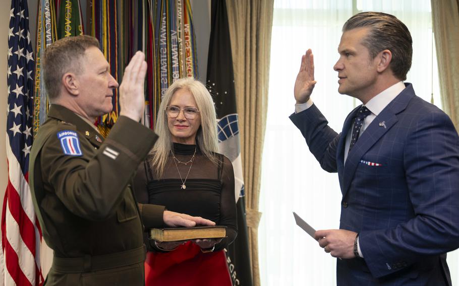 Craig Morgan on the left raises his hand as Pete Hegseth raises his hand opposite him.