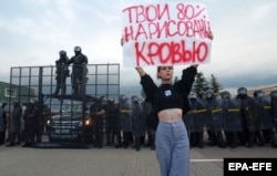 A woman in Minsk holds a poster reading 'Your 80 percent is written in blood' during a protest rally over the official results of the August 2020 presidential election in Belarus.