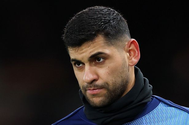 Cristian Romero looks on.