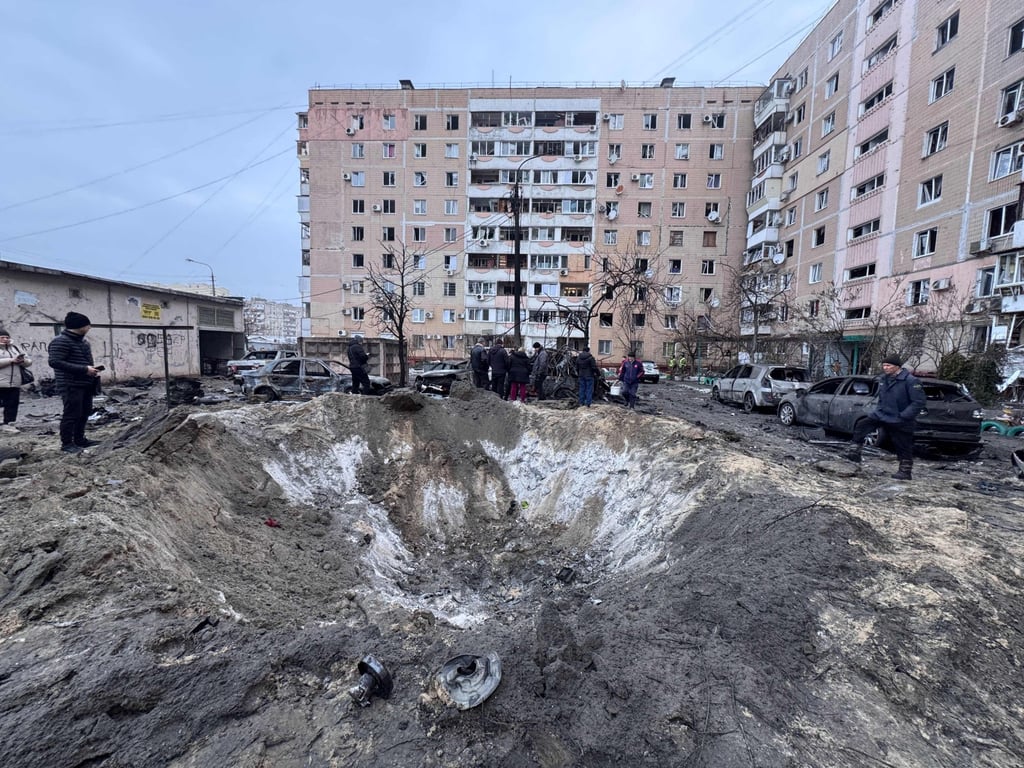 People stand by a crater left in an area hit by an air attack in Zaporizhzhia on Wednesday, amid the Russian invasion of Ukraine. Photo: AFP