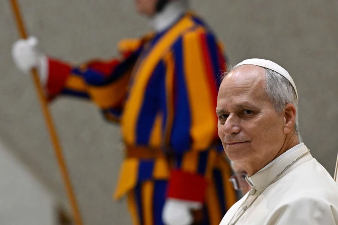 Pope Leo XIV sits during the Jan. 21, 2026, general audience alongside a Swiss Guard at the Vatican.