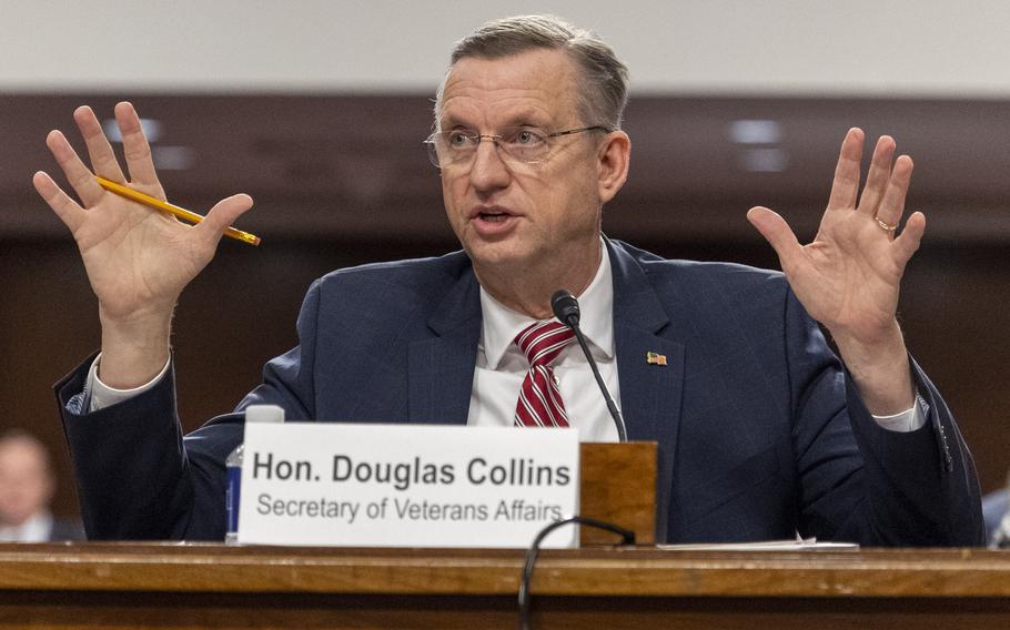 Collins raises his hands as he testifies.