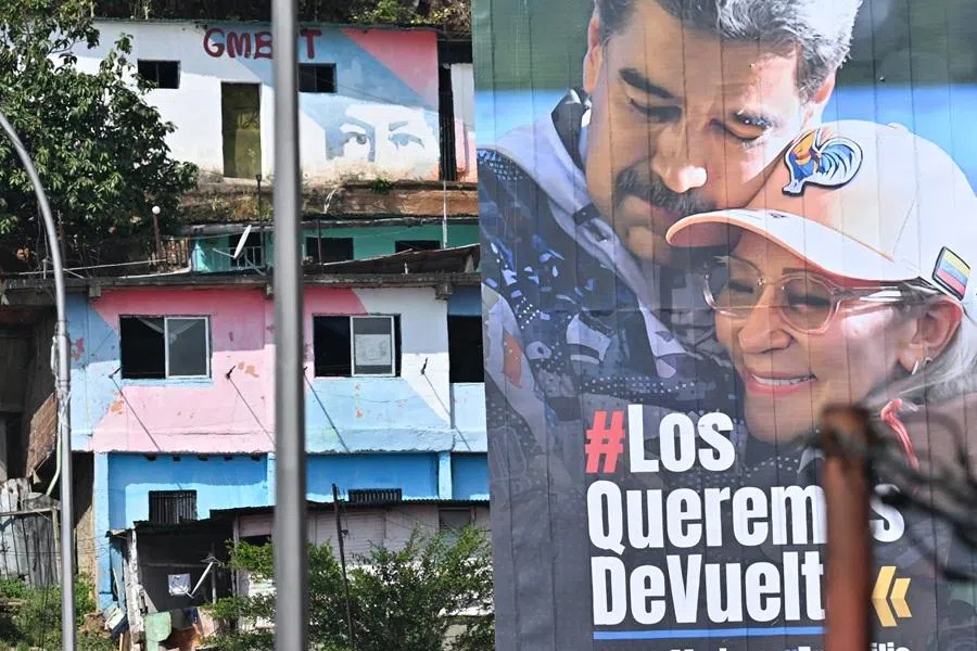 A billboard depicting ousted Venezuela's President Nicolás Maduro and his wife Cilia Flores that reads in Spanish "We want them back, FreeMaduro, FreeCilia" is seen in the Guarataro neighborhood in Caracas on 20 January 2026. (Juan Barreto/AFP)