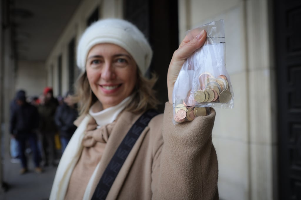 A woman holds euro coins. Photo: AP A woman holds euro coins. Photo: AP