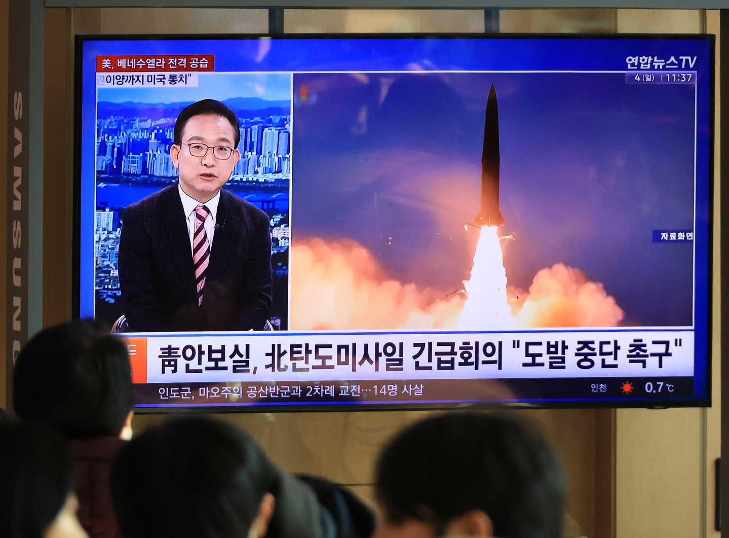 Seoul citizens watch a news broadcast on the news that North Korea fired multiple ballistic missiles into the East Sea on Jan. 4, displayed on a television screen at the Seoul Station in central Seoul on the same day. [YONHAP]