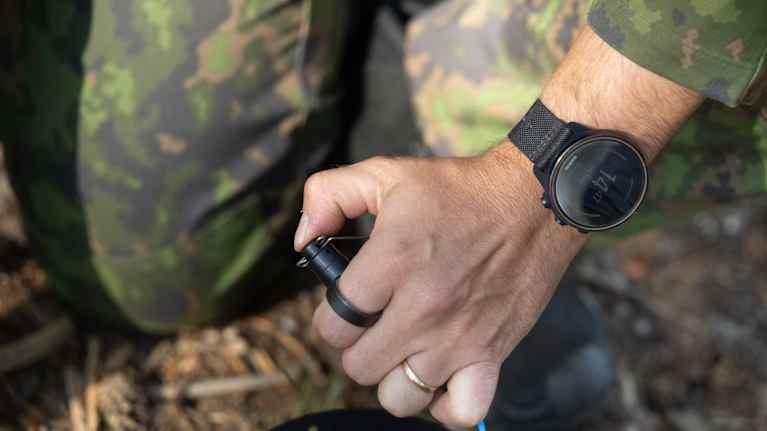 The hand of a person dressed in military gear.
