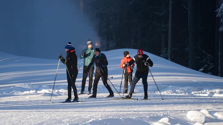 Cross country skiers grouped together in the forest.